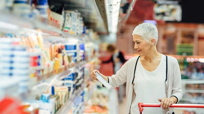 woman checking label of product in supermarket